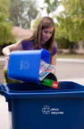 Picture of girl placing recyclables into blue barrel