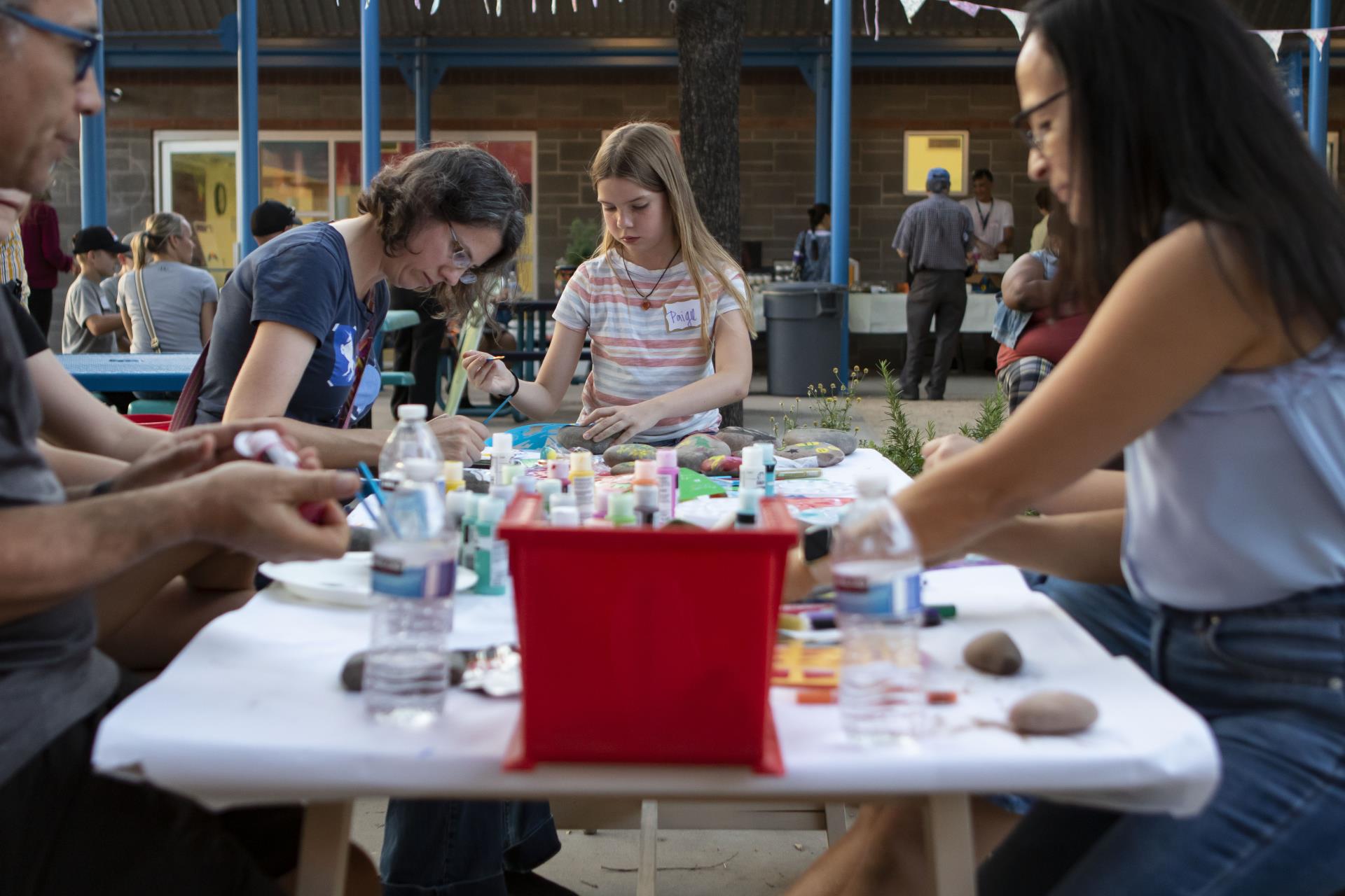 Neighbors painting rocks at the craft table